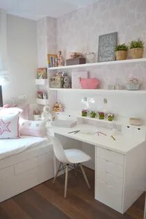 a white desk sitting next to a window in a room with pink wall paper on the...