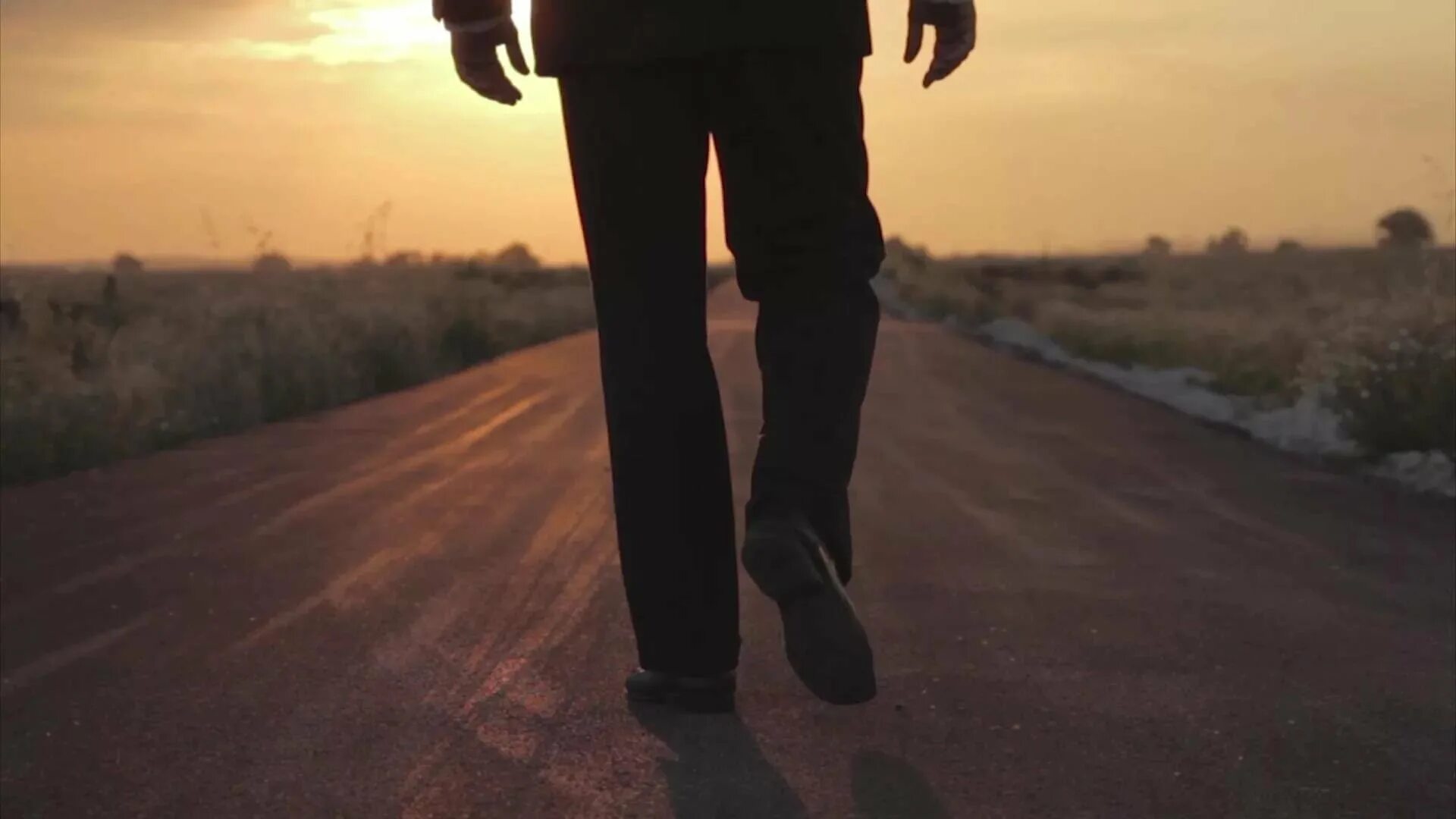 Парень идет по дороге. Человек идет по дороге. Со спины в капюшоне. Парень идет спиной. Парень с рюкзаком.