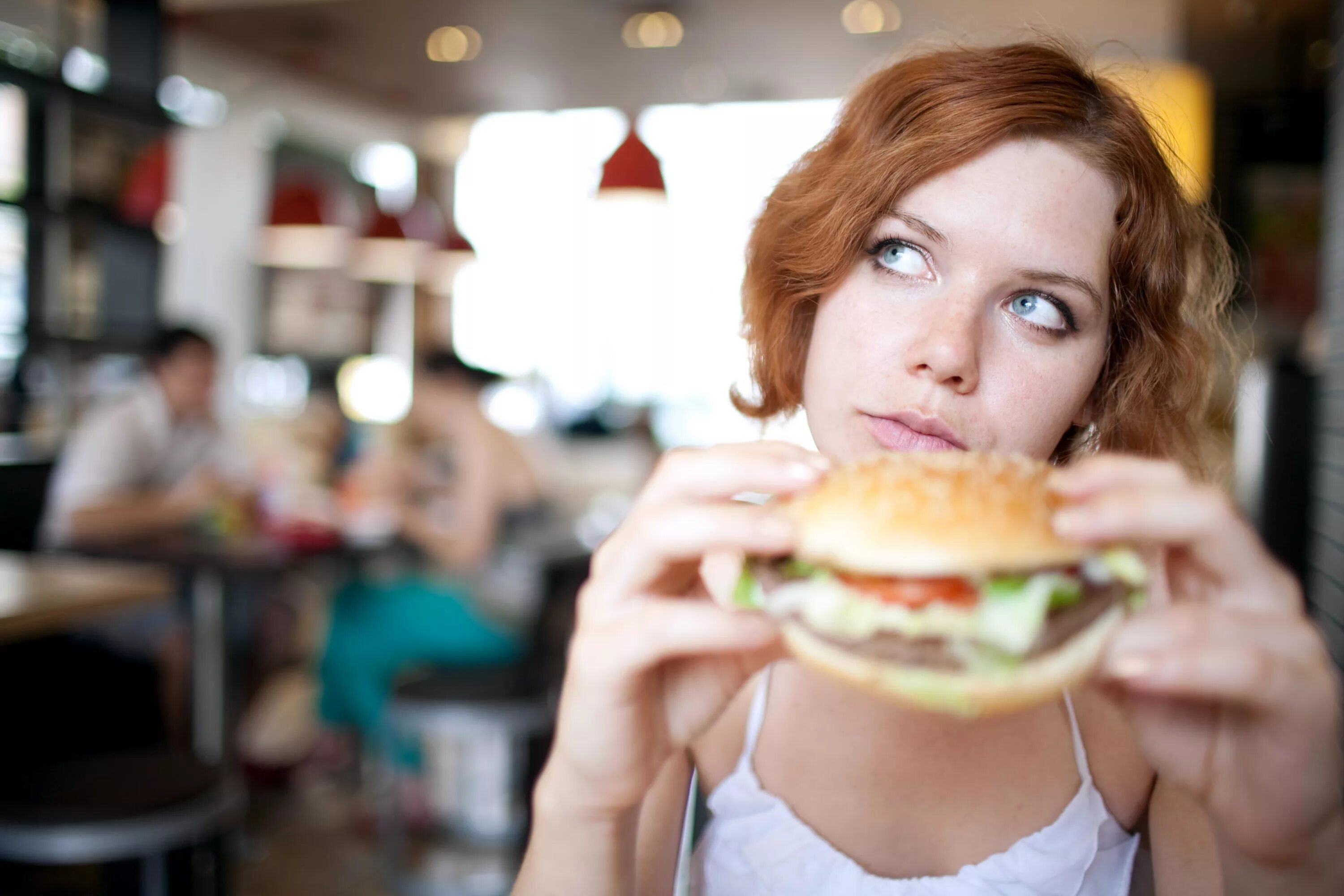 Можно ли каждый день есть фаст фуд. Девушка ест гамбургер. Человек с фастфудом. Люди в фастфуде. Человек ест гамбургер.