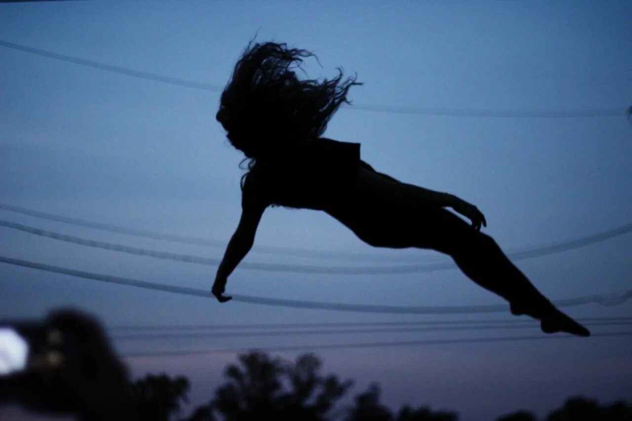 Девушка сидит на шее у парня. Девочка прыгает вниз невысоко. Девочка прыгает на лице. Счастливая девочка. Ноги в прыжке.