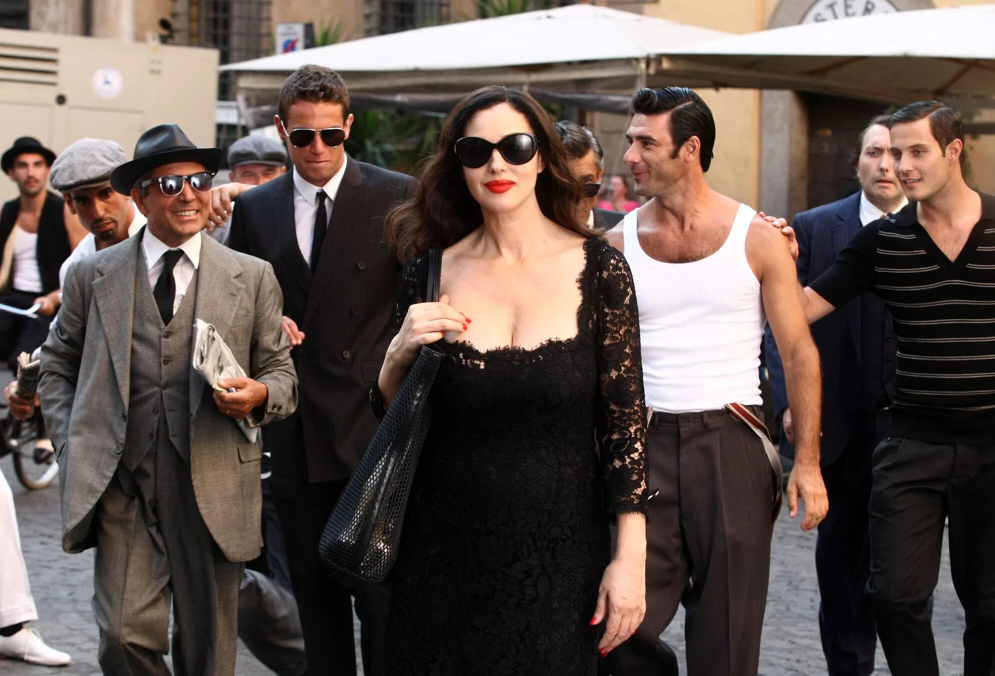 восхищаться кратко. моника беллуччи на улице. почему люди восхищаются. мужчина улыбается. девушка окруженная мужчинами.