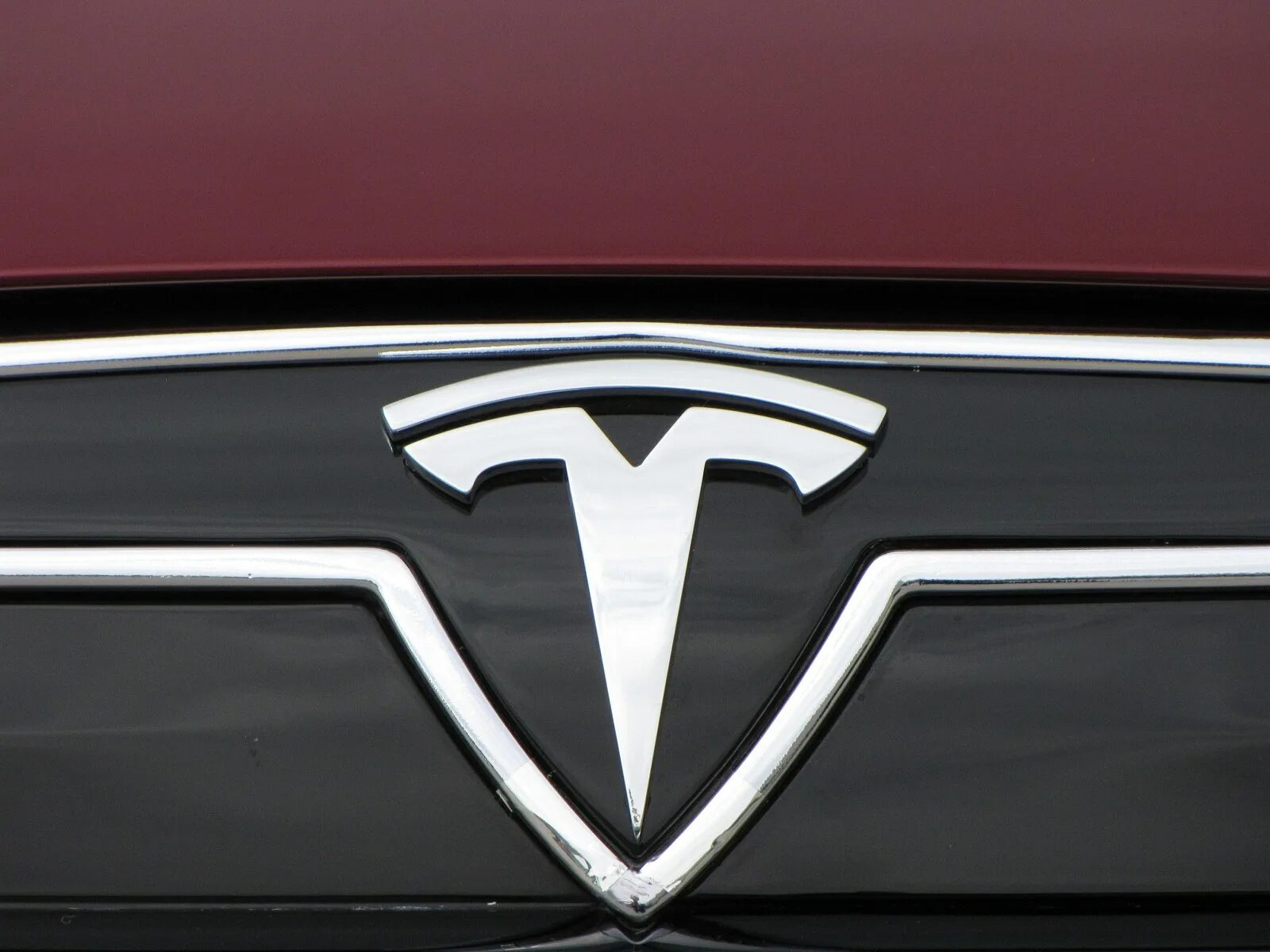 Тесла знак. Тесла логотип авто. Тесла знак на машине. Значок Тесла фото.
