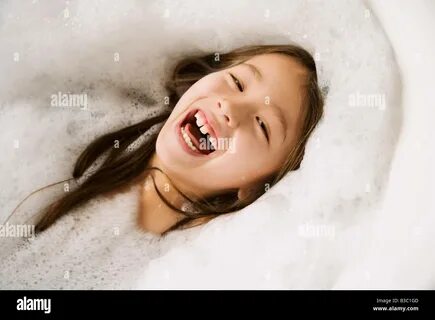 RFB3C1GD–Asian. girl laughing in bubble bath. 