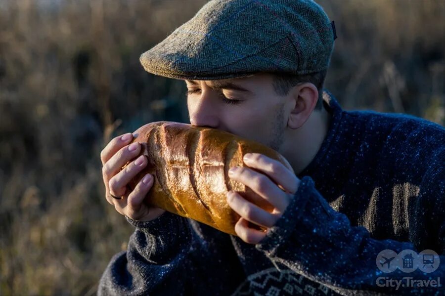 Мужчина ест хлеб. Целует хлеб. Фотосессия с хлебом. Аромат хлеба.