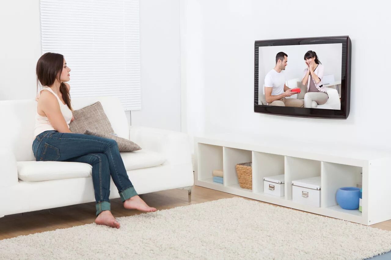 Пока муж смотрит телевизор жена. Женщина у телевизора. Девушка сидит перед телевизором. Женщина на диване перед телевизором. Женщина на диване смотрит телевизор.