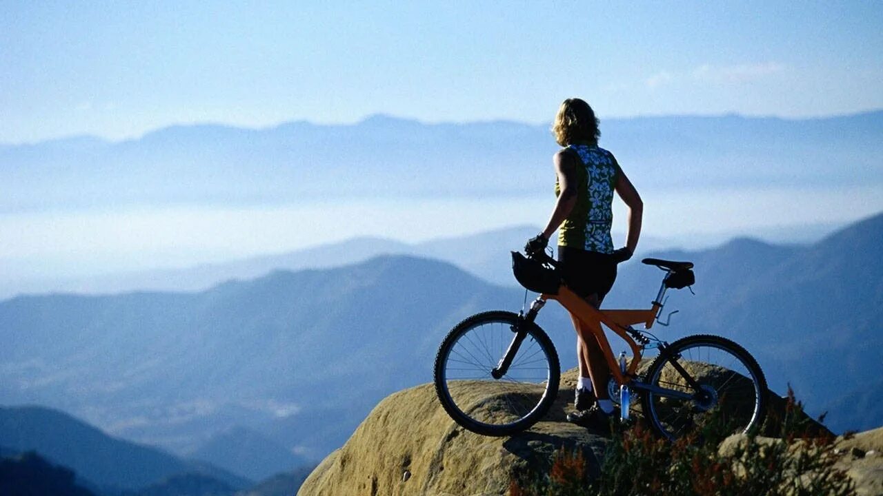 Велосипед едет в гору. Велосипед в горах. Велосипед на фоне гор. Велосипед фон. На горе с велосипедом.