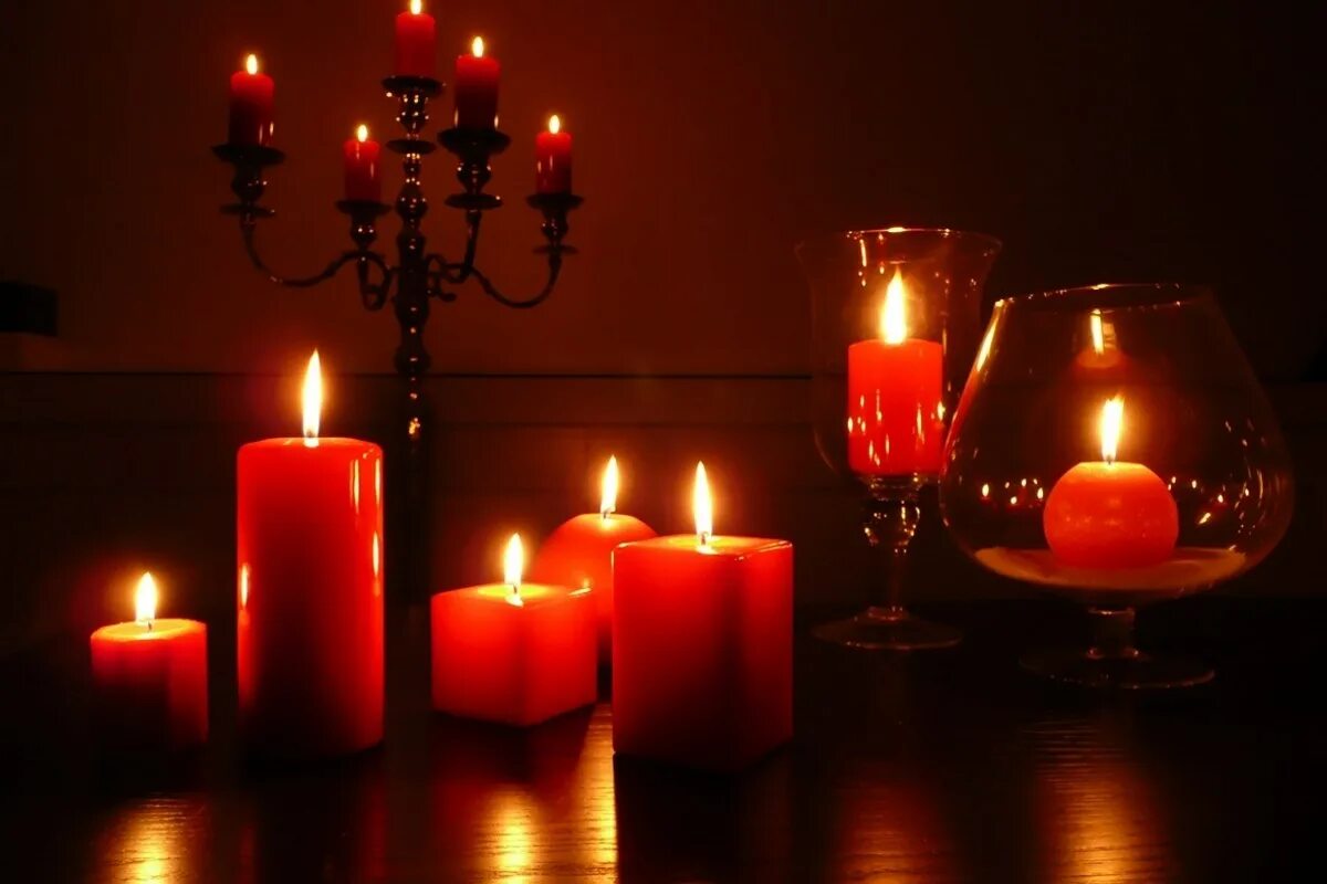 Романтические свечи. Красные магические свечи. Красные свечи в подсвечнике. Красные свечи в темноте.