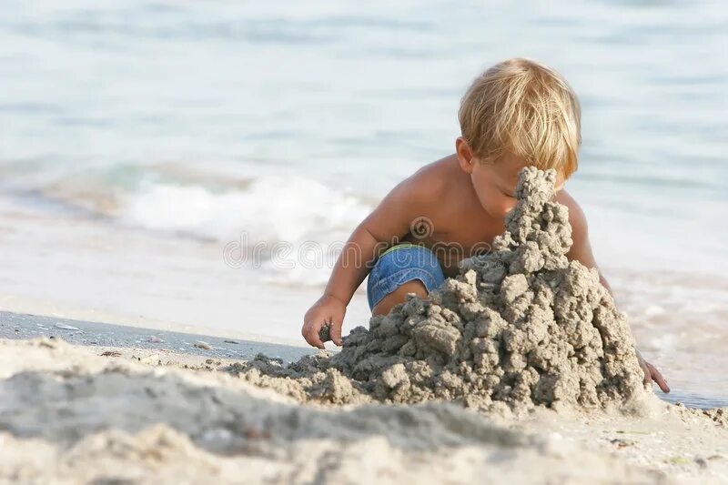 Дети строят песочный замок. Песочные замки детские. Дети строят замок из песка. Дети строят замки из песка на море. Ребенок сидит на песке с игрушками.