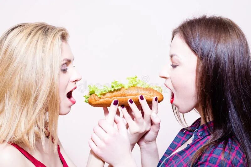 Молодую имеют несколько. Девушка ест хот дог. Девушка с хот догом. Голодная девушка фото. Две девушки едят.