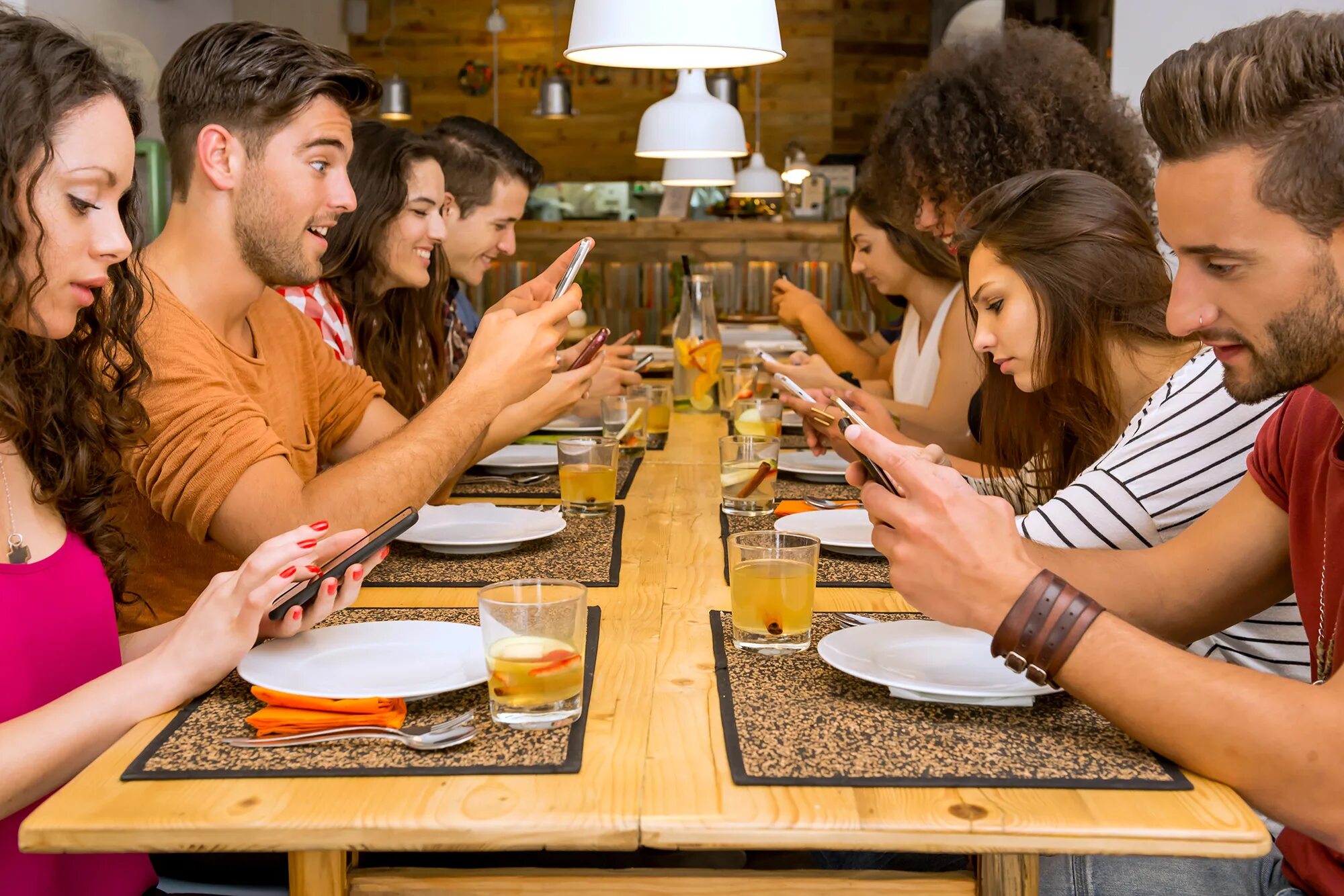 Ужин с друзьями. Люди за столом в ресторане. Люди сидят за столиком в ресторане. Встреча друзей в кафе.