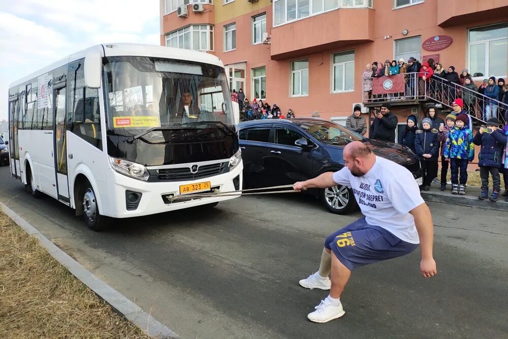 Т ч автобус. Силач тащит автобус. Буксировка автобуса.