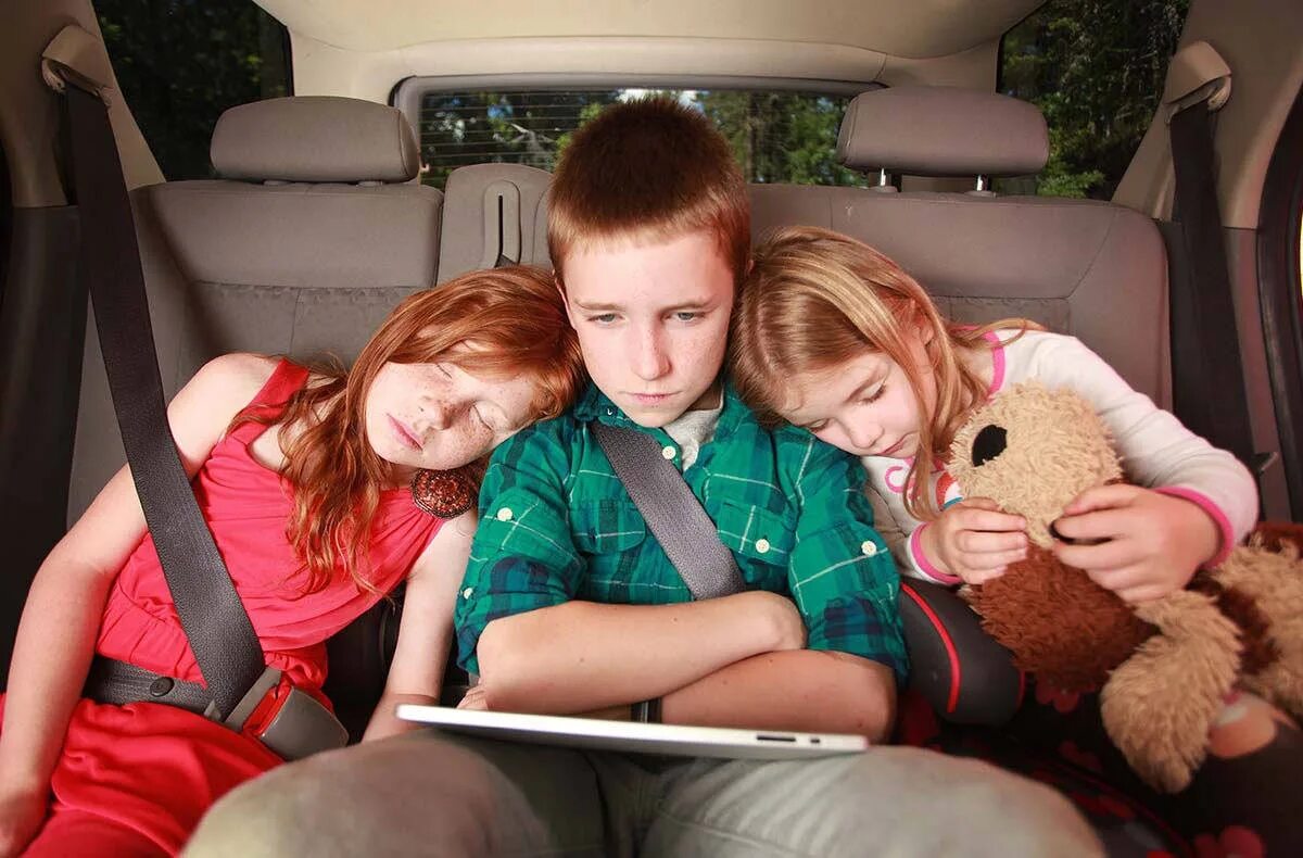 Автомобиль для детей. На заднем сиденье. Трое детей на заднем сидении. Перевозка детей на заднем сидении автомобиля.