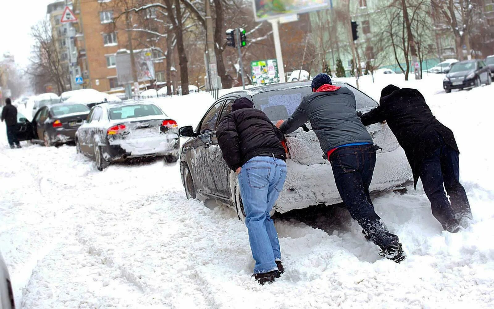 Застревают в сугробах. Толкают машину в снегу. Машина застряла в снегу. Толкают машину из сугроба. Машина застряла в сугробе.
