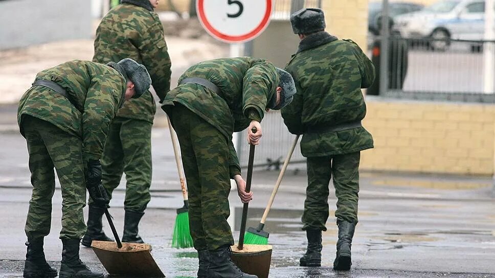 Жалкая россия. Уборка в армии. Солдаты на плацу. Солдат подметает ломом. Уборка территории в армии.