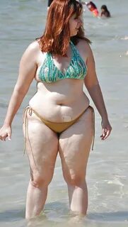This plump, pale girl is not a bit shy about wearing her tiny bikini at the...