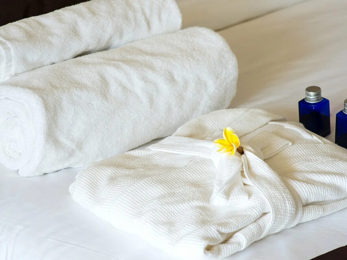 Поменять полотенце. Полотенца на кровати. Полотенца в гостиничном номере. Полотенца и халаты для гостиниц. Ножное полотенце на кровати.