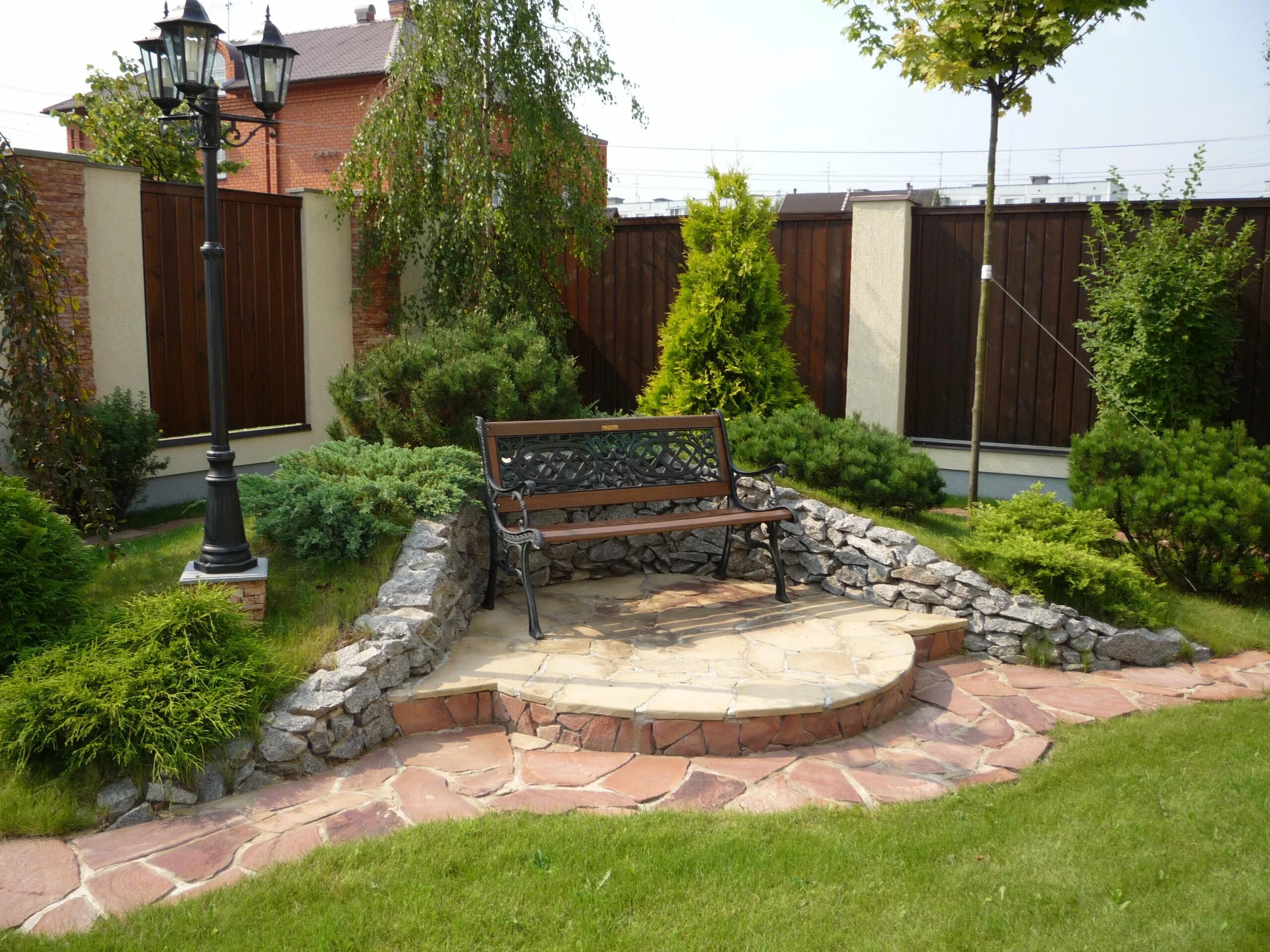 Угловая клумба с туями. Дизайнерские клумбы перед домом. Клумбы во дворе. Дизайнерские клумбы перед домом. Ландшафт придомовой территории.