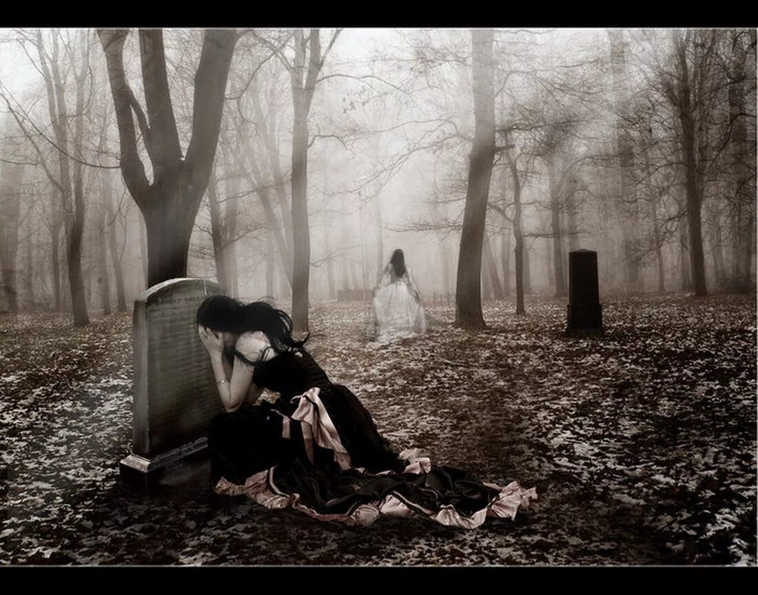 Девушка плачет на кладбище.