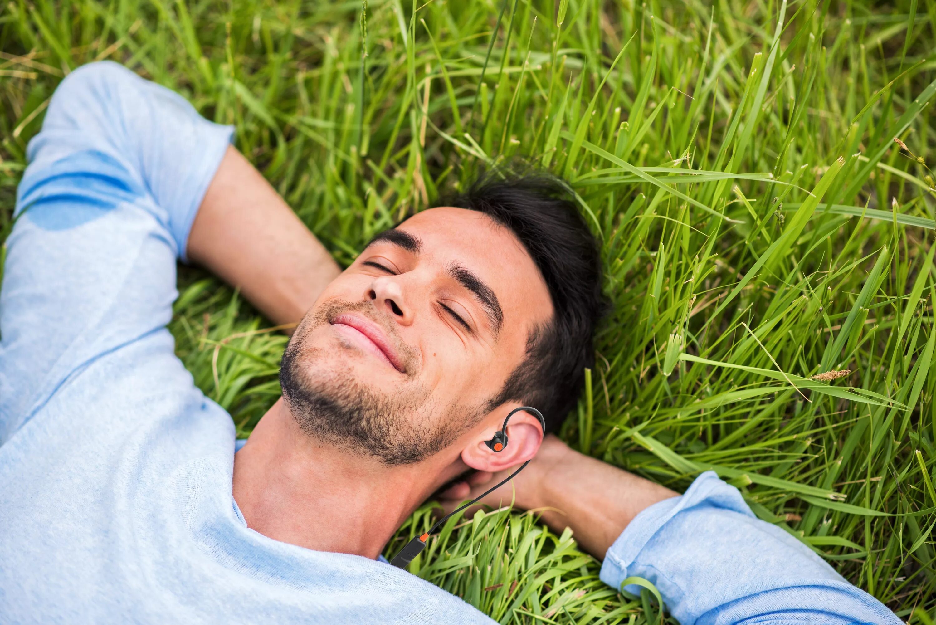 Счастливый человек с закрытыми глазами. Счастливый мужчина. Мужчина лежит с закрытыми глазами. Парень улыбается на траве. Rest man