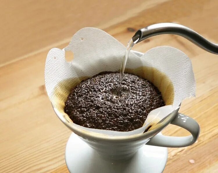 Приготовление заварки. Фильтр для молотого кофе. Кофе для заварки в кружке. Кофе заваривается в чашке. Заварка кофе.