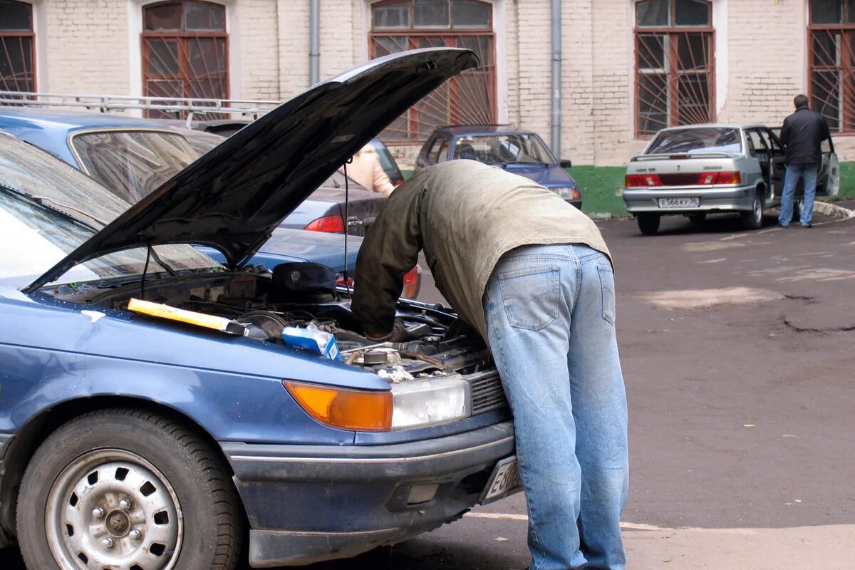 Ремонт автомобиля причины. Человек чинит машину. Мужчина ремонтирует машину. Мужчина чинит машину. Мужик чинит тачку.