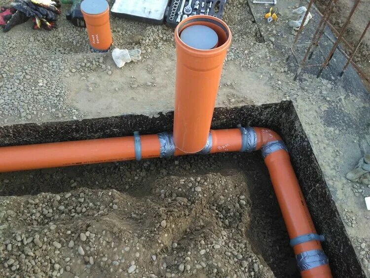Канализационная труба оранжевая. Прокладка канализации. Прокладка канализационных труб под фундаментом. Рыжая труба для канализации. Сера в канализационных трубах