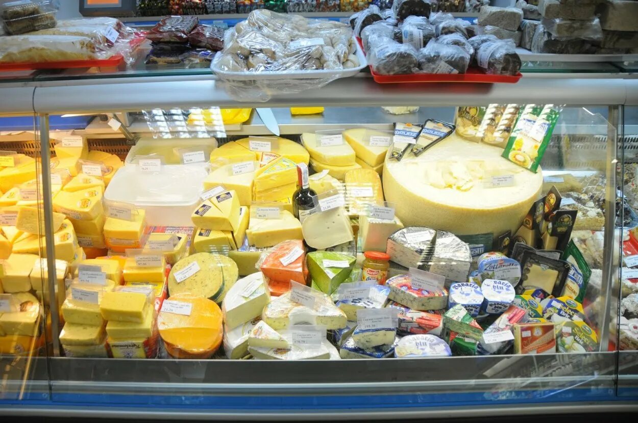 Ассортимент сыров в магазине. Выкладка сыров. выкладка сыров в магазине. сырная витрина выкладка. выкладка сыров на витрине.