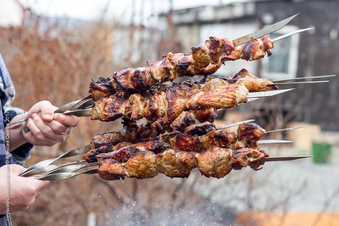 В чем суть шашлыка. Шашлык на шампуре. Шашлык на шампуре в руке. Мясо на шампуре. Шашлык на шампуре на природе.