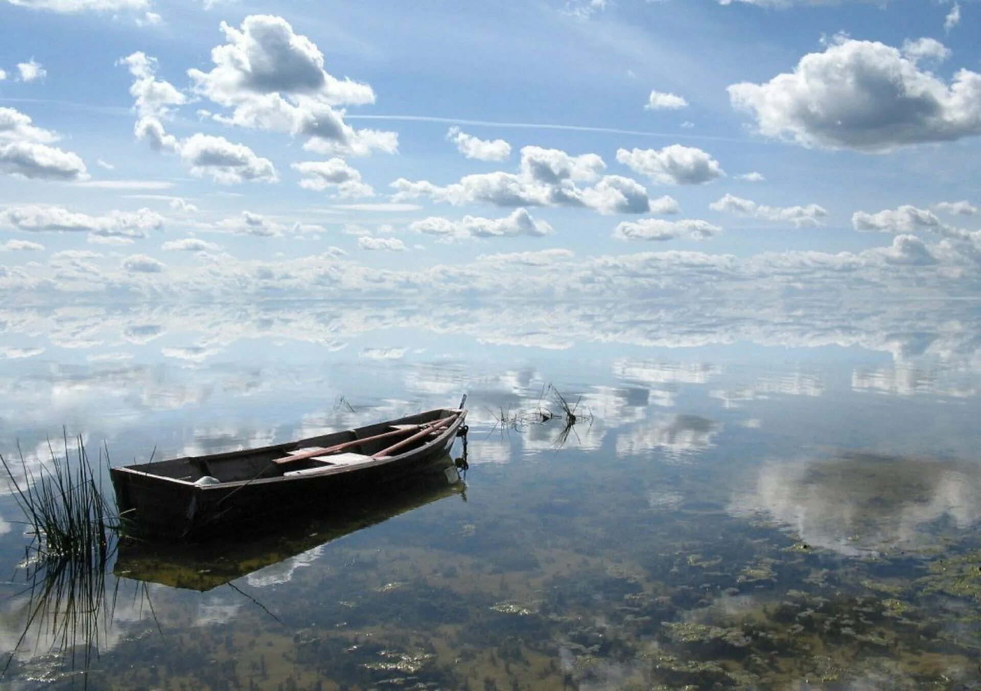 Облака плывут в воде. Лодка на воде. Отражение облаков в воде. Лодка на озере. Отражение неба в воде.