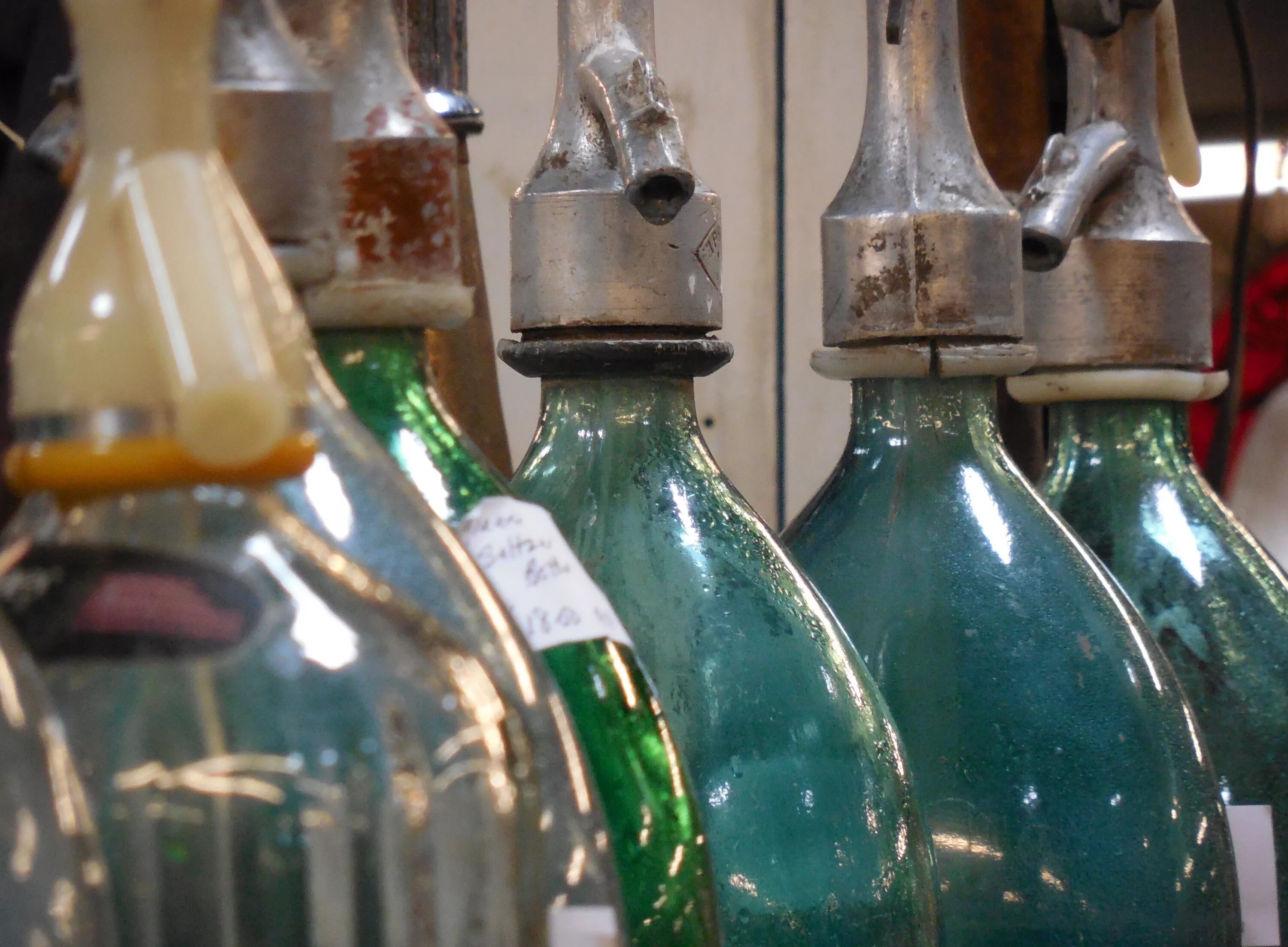 Старинные бутылки из стекла. Алкогольные напитки в стеклянных бутылках. Трехлитровая бутылка. Коллекция пустых бутылок.