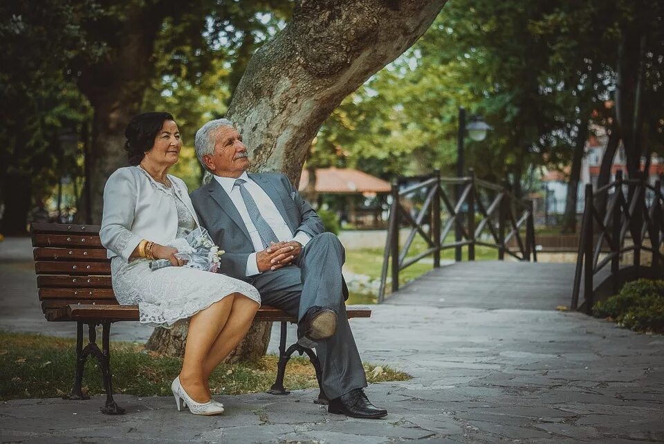 Пара в возрасте на скамейке. Романтика на пенсии. Жизнь с мужем в старости. Жених и невеста сидят на скамейке. 15 лет это старость