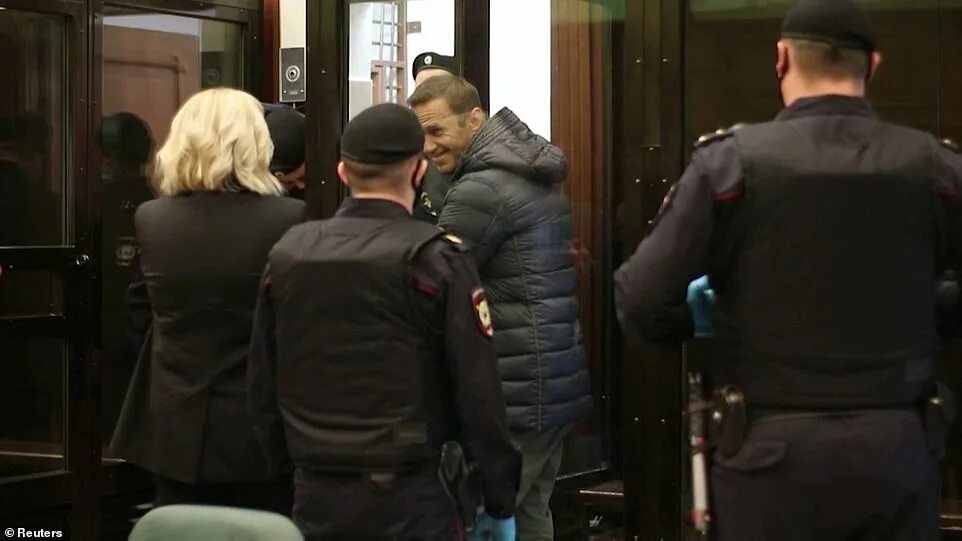 Навальный в суде. Навальный за стеклом. Навальный прибыл в Москву. Навальный улыбается в суде.