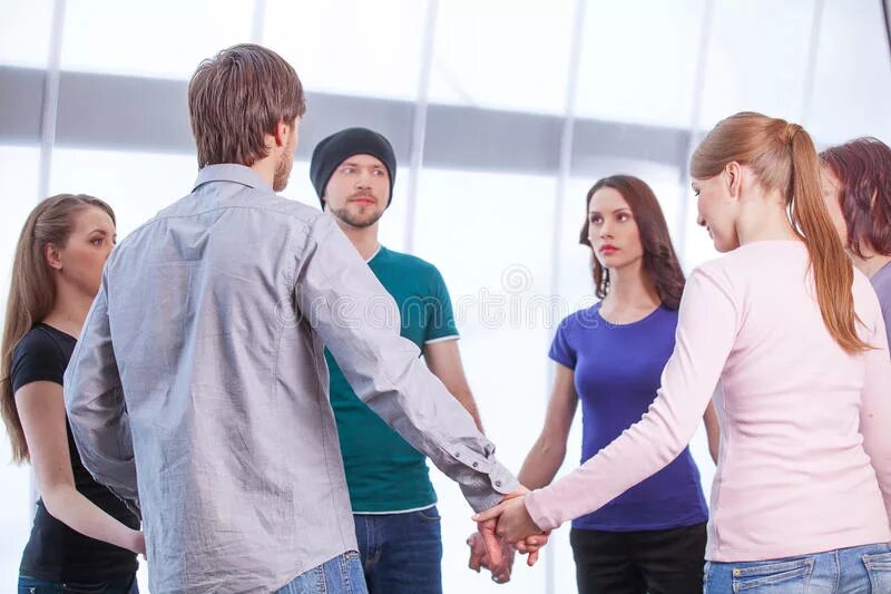 Улыбающийся человек. Дети в разноцветных футболках. Группа людей. Группа людей со спины. Молодые люди стоят.