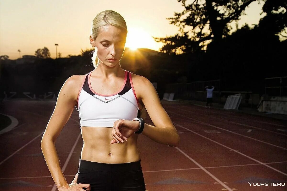 Бегущий человек на стадионе. Упражнения для бегунов. Занимается спринтерским бегом к концу тренировки. Женщина бежит. Бег на прямых ногах.
