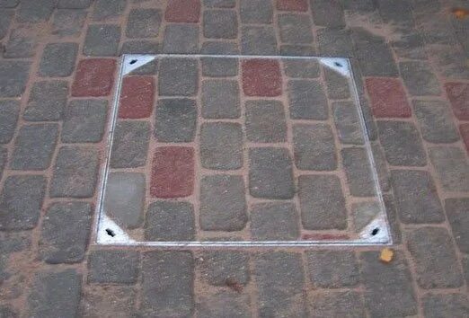 Брусчатка вокруг канализационного люка. Канализационный люк в брусчатке. Люк канализационный под брусчатку. Люк в тротуарной плитке. Канализационный люк в тротуарной плитке.