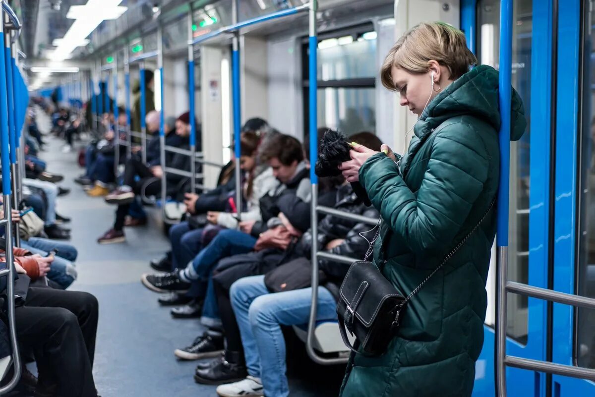 Подросток в московском метро. Люди в общественном транспорте. Люди в наушниках в метро. Люди со смартфонами в метро. Человек с телефоном в транспорте.