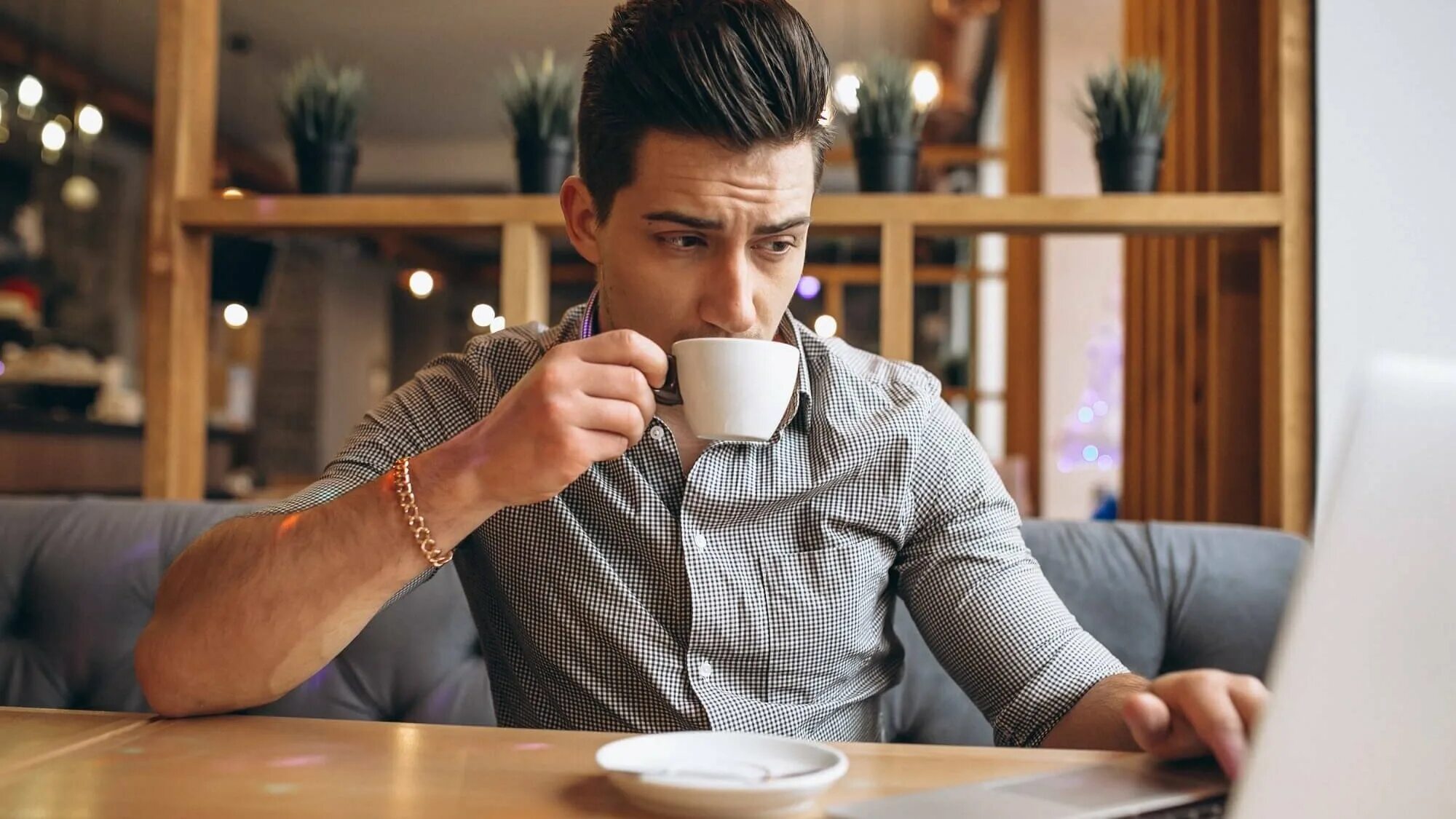 Парень пьет кофе. Мужик с чашкой кофе. Мужчина за столиком в кафе. Люди в кофейне.