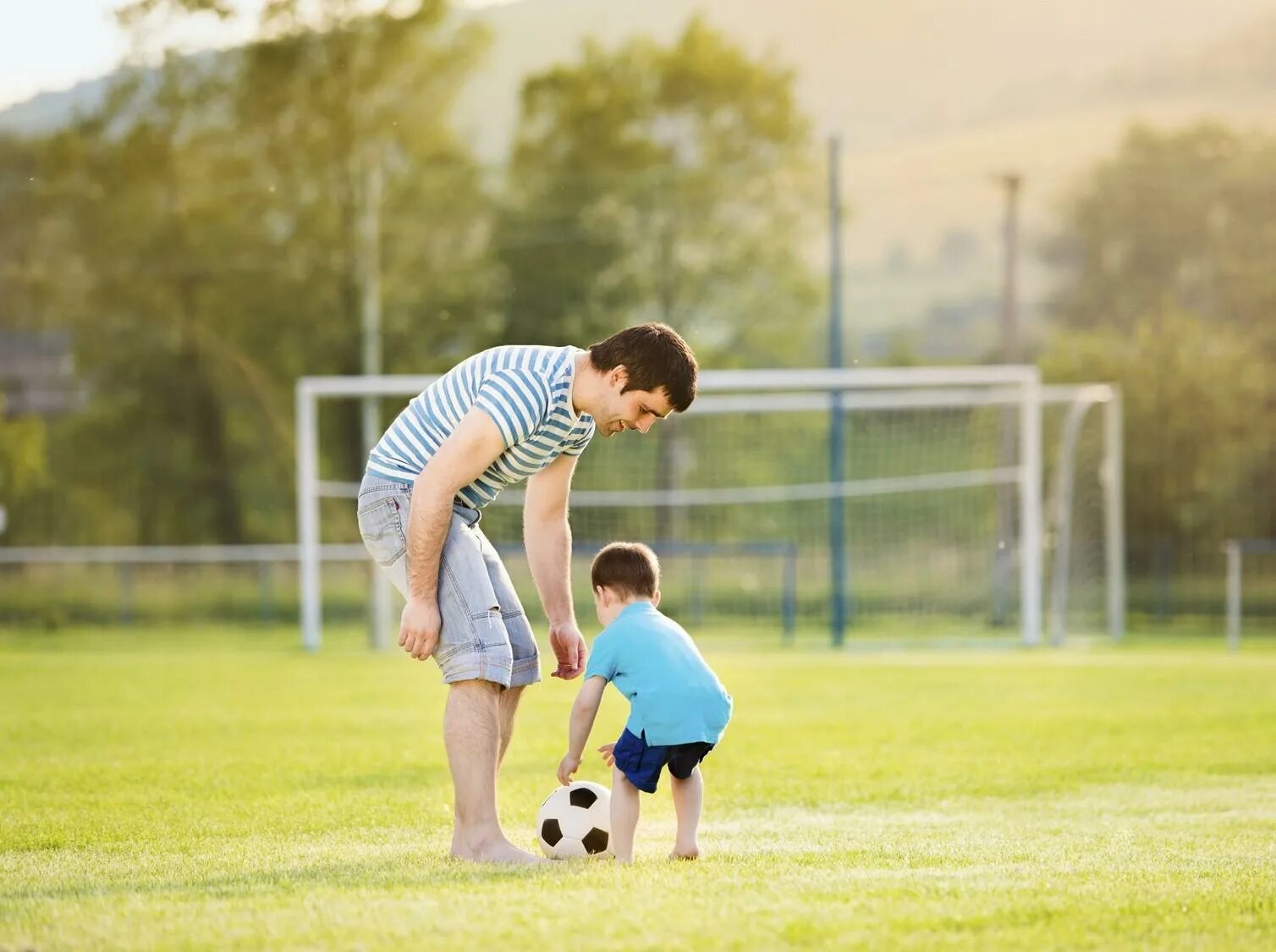 Папа с сыном играют в футбол. Взрослые и дети играют в футбол. Мальчик на футбольном поле. Фотосессия детский футбол. Папы играют в футбол