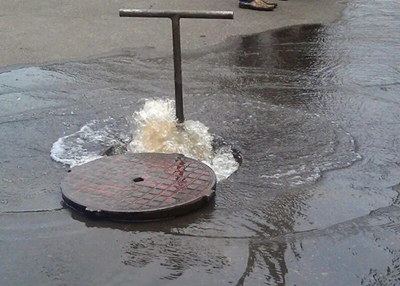 Течет вода из люка. Вода из канализационного люка. Ванюшок из люка. Люк на асфальте. Люк канализационный с водой.