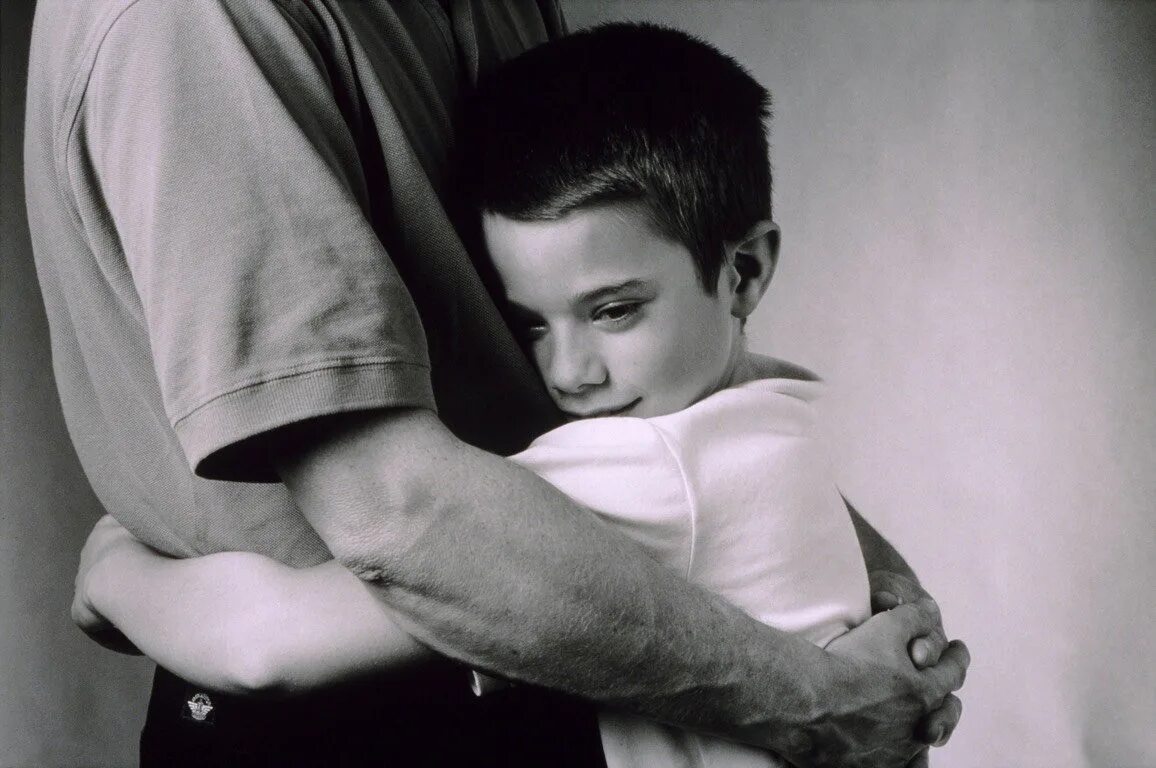 Мальчик с отцом. Папа обнимает сына. Мужчина обнимает ребенка. Мальчик обнимает отца. Проводит и мужа и сына
