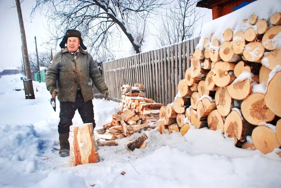 Дед рубит. Дрова. Заготовка дров. Нарубленные дрова. Дрова заготавливают.