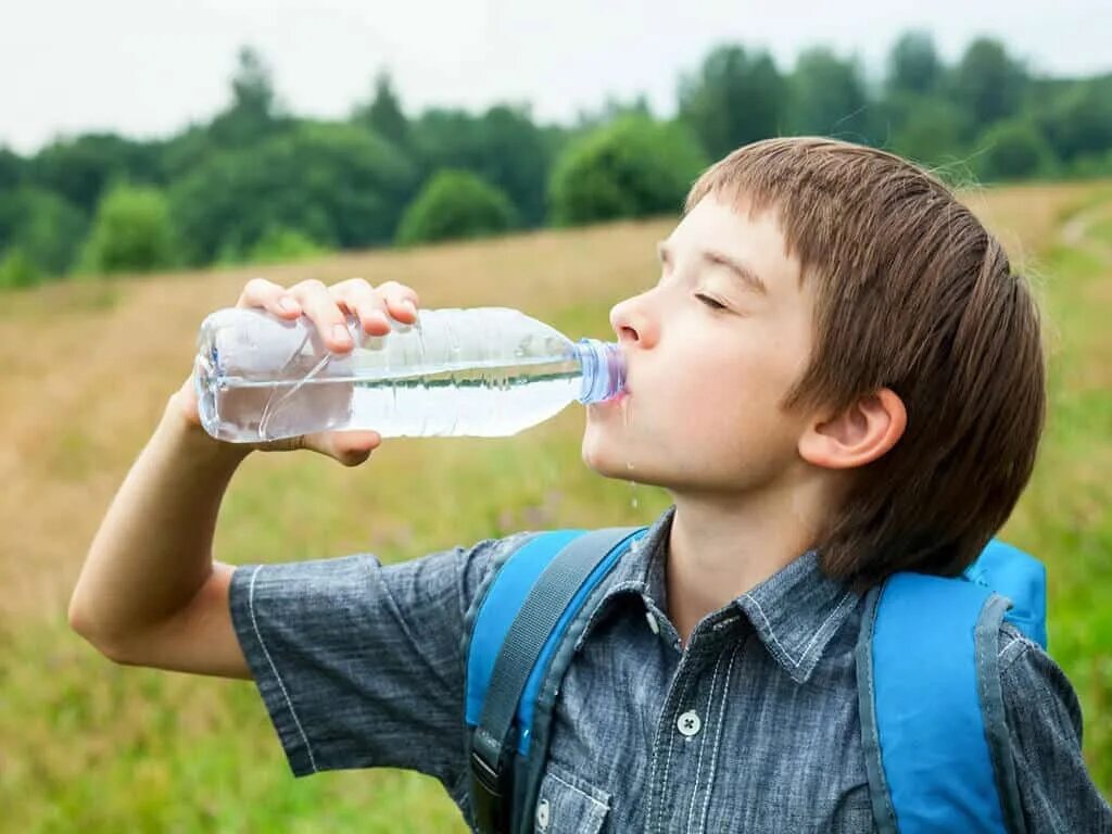 Дети пьют из бутылки. Бутылка для воды для мальчика. Мальчик пьет воду. Ребенок пьет воду. Школьник и вода.