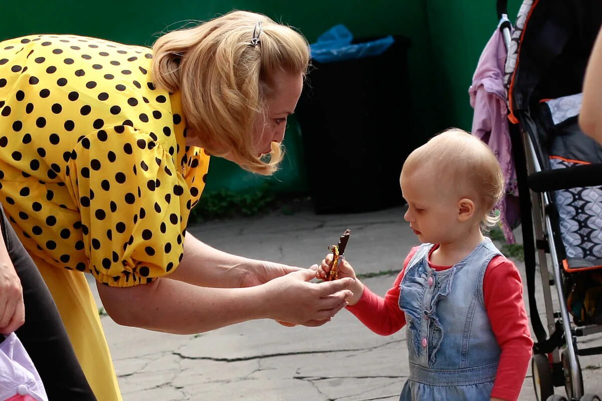 Мама угощает ребенка. Женщина дает ребенку конфету. Дети улицы. Бабушка с ребенком на улице. Мама не хочет приходить