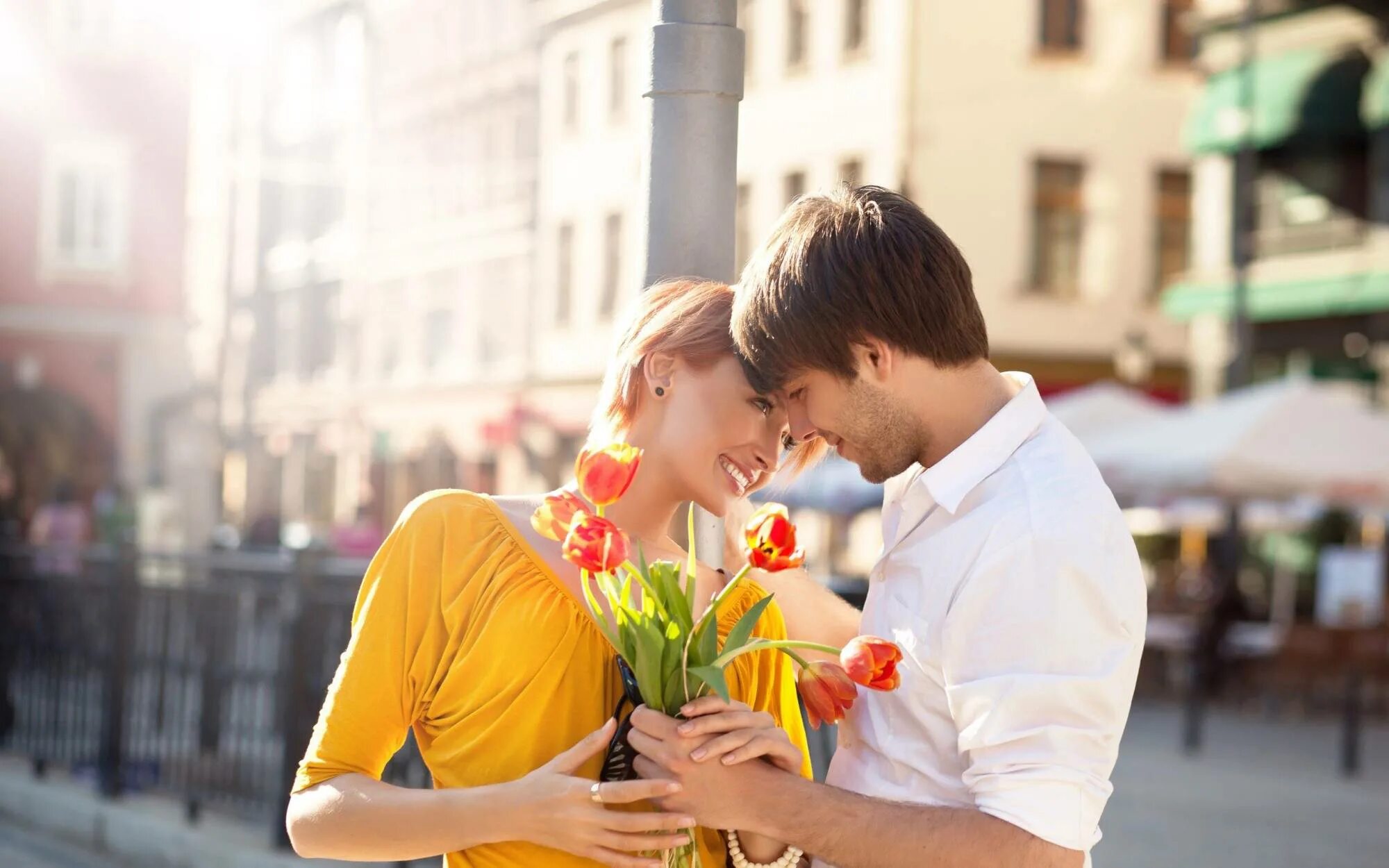 Парень дарит девушке цветы. Мужчина дарит цветы женщине. Счастливые влюбленные. Романтическое свидание.