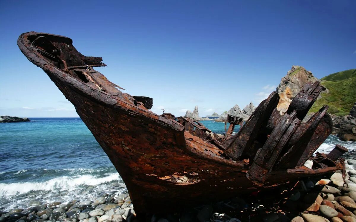 Разбившаяся лодка. Обломки корабля. Разрушенный деревянный корабль. Затонувший деревянный корабль. Разбитый корабль на берегу.