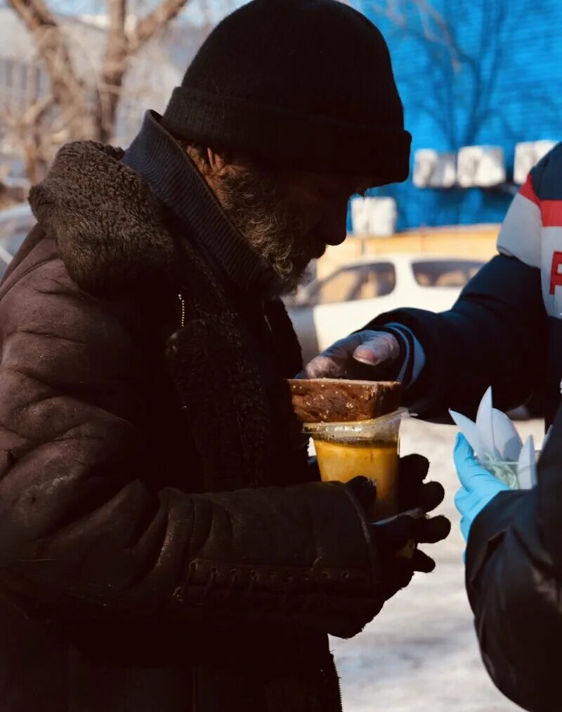 Бомжи санкт петербурга. Человек помогает бездомному человеку. Помощь бездомным. Благотворительность бездомным. Образ жизни бездомных людей.