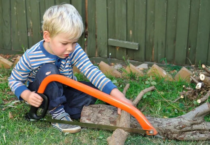 ребенок пилит. игрушечная бензопила для детей. набор столяра для мальчика. мальчик пилит доску. ребенок пилит.