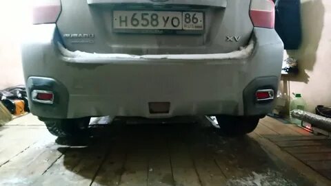 Под задним бампером