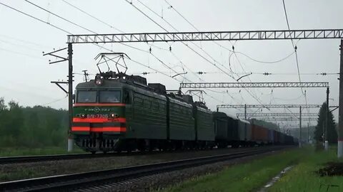 Электровоз с грузовым поездом приветливый машинист