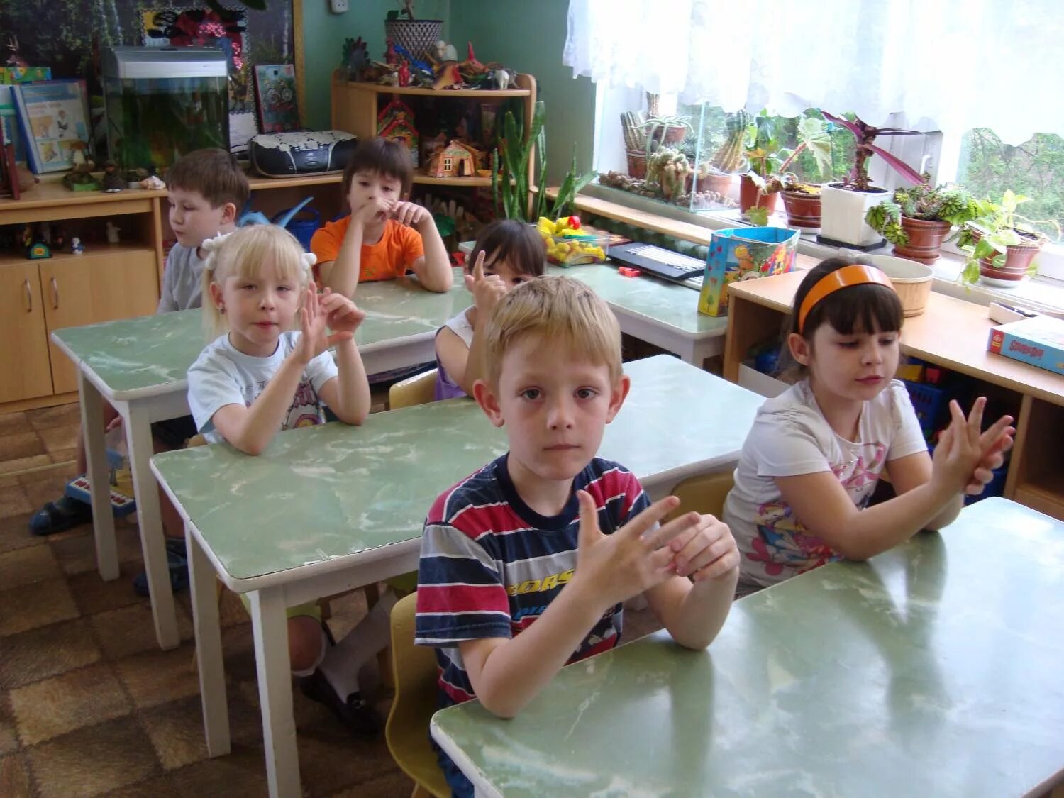 Село пальчики. Дети на занятии в ДОУ. Дети сидят за партами в детском саду. Дети за столом в детском саду. Дети в детском саду за партами.